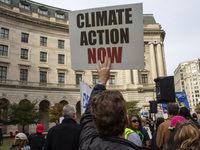 Environmental activists rally to demand climate action before US President-elect Donald Trump takes office in Washington, DC, on November 17...