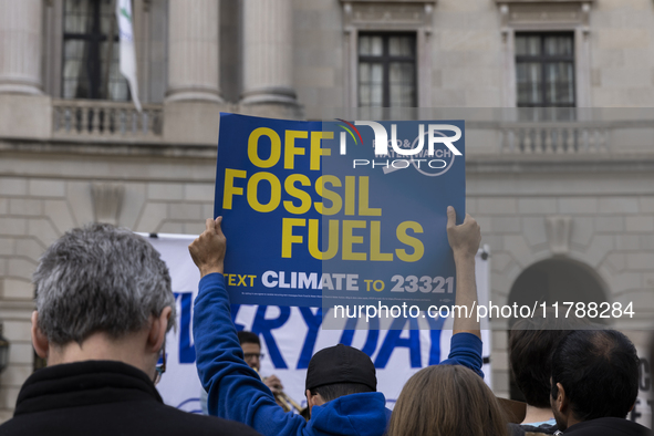 A climate protester holds a sign while environmental activists demonstrate outside the Federal Triangle Metro Station in Washington DC, USA,...