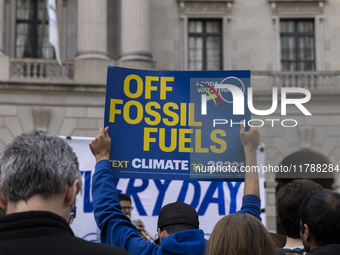 A climate protester holds a sign while environmental activists demonstrate outside the Federal Triangle Metro Station in Washington DC, USA,...