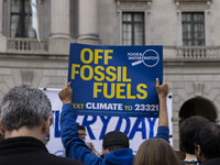 A climate protester holds a sign while environmental activists demonstrate outside the Federal Triangle Metro Station in Washington DC, USA,...