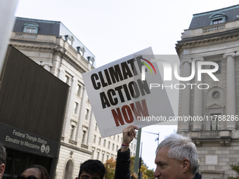 A climate protester holds a sign while environmental activists demonstrate outside the Federal Triangle Metro Station in Washington DC, USA,...