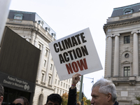 A climate protester holds a sign while environmental activists demonstrate outside the Federal Triangle Metro Station in Washington DC, USA,...