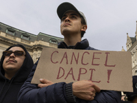 A climate protester holds a sign while environmental activists demonstrate outside the Federal Triangle Metro Station in Washington DC, USA,...