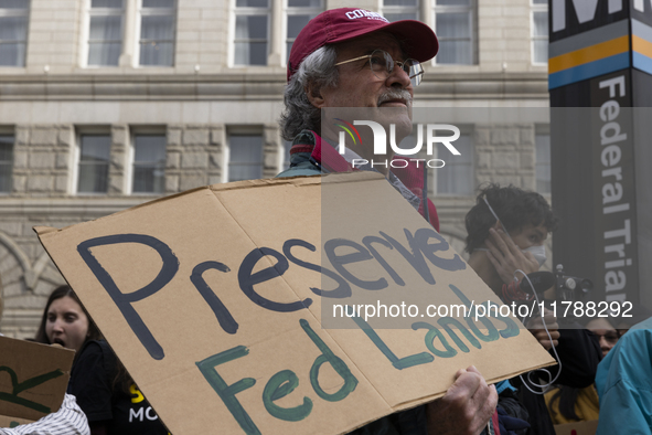 A climate protester holds a sign while environmental activists demonstrate outside the Federal Triangle Metro Station in Washington DC, USA,...