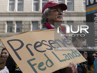 A climate protester holds a sign while environmental activists demonstrate outside the Federal Triangle Metro Station in Washington DC, USA,...