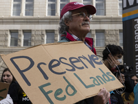 A climate protester holds a sign while environmental activists demonstrate outside the Federal Triangle Metro Station in Washington DC, USA,...