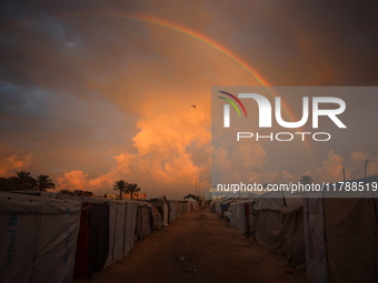 A rainbow arches across the sky above the tents of internally displaced persons who flee the Israeli military bombing and incursion in the n...