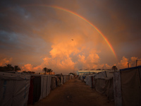 A rainbow arches across the sky above the tents of internally displaced persons who flee the Israeli military bombing and incursion in the n...