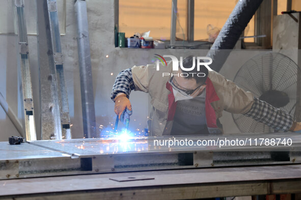 A worker produces intelligent devices in a manufacturing workshop in Binzhou City, Shandong Province, China, on November 18, 2024. 