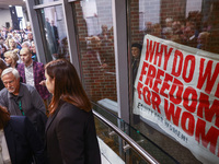 People hold a banner protesting outside a building during the opening of 'Manifesto' exhibition in the Centre Of Contemporary Art in Torun,...