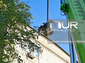 Workers of the State Emergency Service remove part of a Russian missile that hits a five-storey apartment building in the Pecherskyi distric...