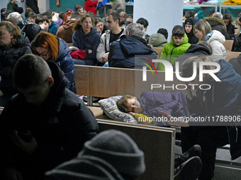 A child sleeps on a bench in a bomb shelter during an air alert caused by a large-scale Russian missile and drone attack in Kyiv, Ukraine, o...