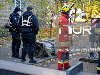 In Kyiv, Ukraine, on November 17, 2024, law enforcers stand by a fragment of a Russian missile removed from a five-storey apartment building...