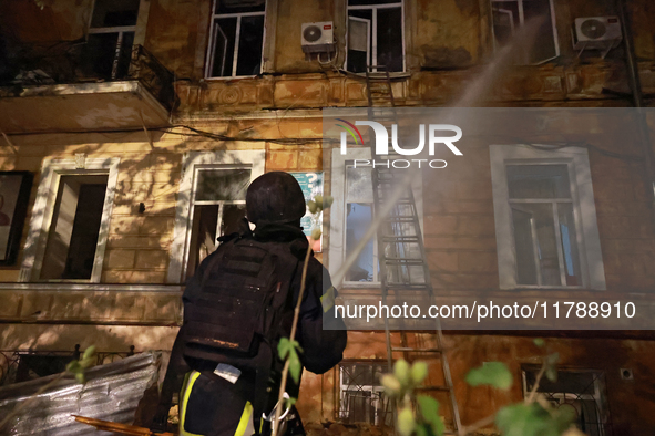 A firefighter sprays water during a response effort to a fire in a three-story residential building caused by a Russian missile and drone at...