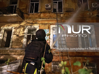 A firefighter sprays water during a response effort to a fire in a three-story residential building caused by a Russian missile and drone at...