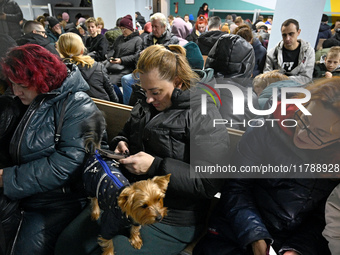 In Kyiv, Ukraine, on November 17, 2024, people with pets stay in a bomb shelter during an air alert caused by a large-scale Russian missile...