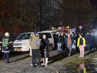 People watch a response effort to a fire in a three-story residential building caused by a Russian missile and drone attack in central Odesa...