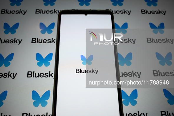 The Bluesky logo appears on a smartphone screen and as a background on a computer screen in this photo illustration in Athens, Greece, on No...