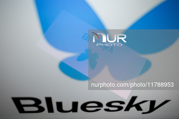 The Bluesky logo appears on a smartphone screen and as a background on a computer screen in this photo illustration in Athens, Greece, on No...