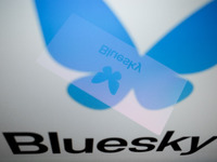 The Bluesky logo appears on a smartphone screen and as a background on a computer screen in this photo illustration in Athens, Greece, on No...