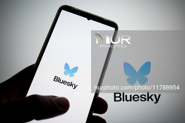 The Bluesky logo appears on a smartphone screen and as a background on a computer screen in this photo illustration in Athens, Greece, on No...