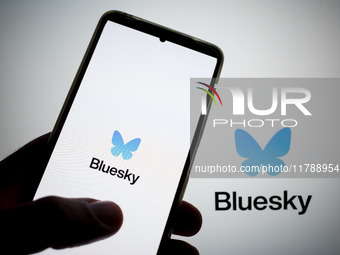 The Bluesky logo appears on a smartphone screen and as a background on a computer screen in this photo illustration in Athens, Greece, on No...