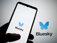 The Bluesky logo appears on a smartphone screen and as a background on a computer screen in this photo illustration in Athens, Greece, on No...