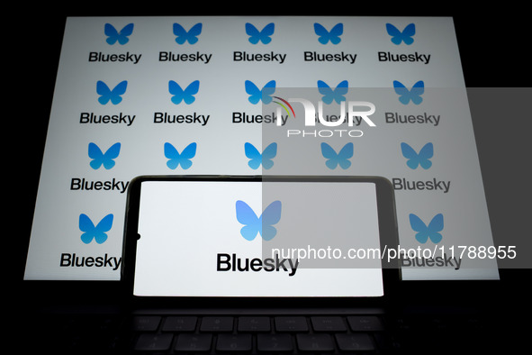 The Bluesky logo appears on a smartphone screen and as a background on a computer screen in this photo illustration in Athens, Greece, on No...