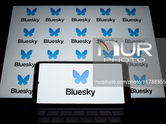 The Bluesky logo appears on a smartphone screen and as a background on a computer screen in this photo illustration in Athens, Greece, on No...