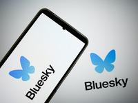 The Bluesky logo appears on a smartphone screen and as a background on a computer screen in this photo illustration in Athens, Greece, on No...