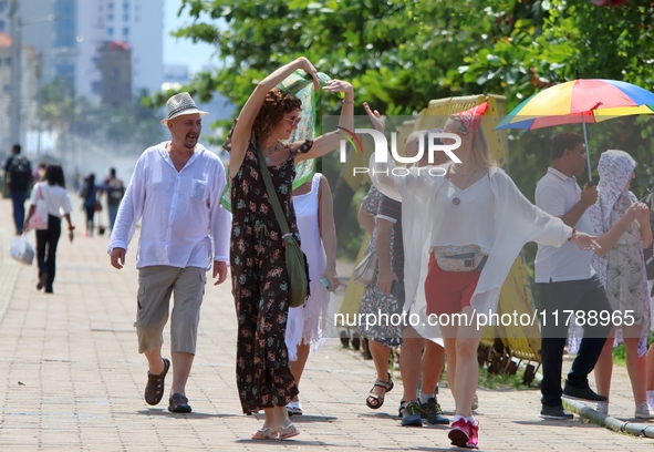 Tourists pose for a photograph near Galle Face Green in Colombo, Sri Lanka, on November 18, 2024. 