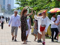 Tourists pose for a photograph near Galle Face Green in Colombo, Sri Lanka, on November 18, 2024. (