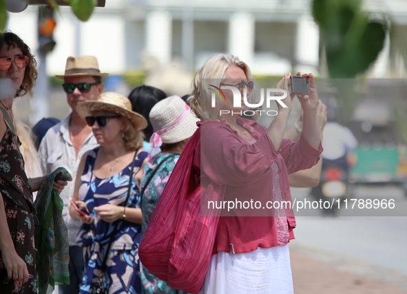 A tourist captures a photograph with her smartphone near Galle Face Green in Colombo, Sri Lanka, on November 18, 2024. 