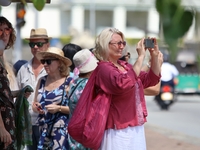 A tourist captures a photograph with her smartphone near Galle Face Green in Colombo, Sri Lanka, on November 18, 2024. (