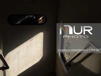 An Iranian woman sits on a train traveling in western Tehran, Iran, on November 17, 2024. (