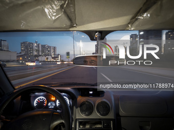 An Iranian Internet-taxi driver drives along an expressway in the Chigger neighborhood in northwestern Tehran, Iran, on November 17, 2024, a...