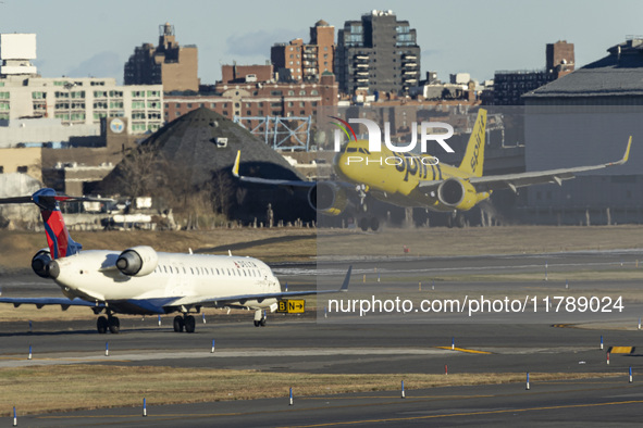 Spirit Airlines Airbus A320NEO aircraft spotted flying for landing at LaGuardia Airport, next to a Delta Air Lines airplane. The iconic yell...