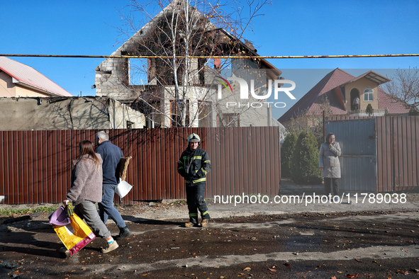 A firefighter stands among people in the street outside a house damaged by a large-scale Russian missile strike in the Odesa region, Ukraine...