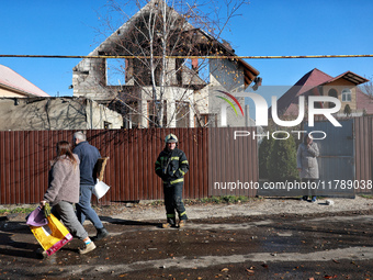 A firefighter stands among people in the street outside a house damaged by a large-scale Russian missile strike in the Odesa region, Ukraine...