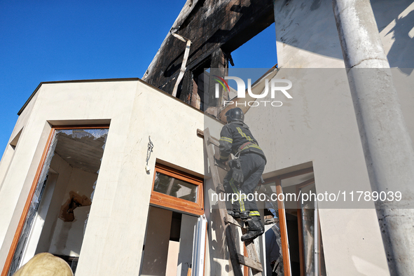 A firefighter goes up the ladder at a house damaged by a large-scale Russian missile strike in the Odesa region, Ukraine, on November 17, 20...