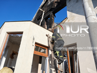 A firefighter goes up the ladder at a house damaged by a large-scale Russian missile strike in the Odesa region, Ukraine, on November 17, 20...