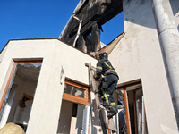 A firefighter goes up the ladder at a house damaged by a large-scale Russian missile strike in the Odesa region, Ukraine, on November 17, 20...