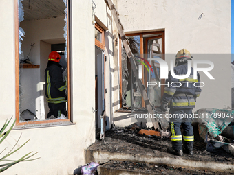 Firefighters work at a house damaged by a large-scale Russian missile strike in the Odesa region, southern Ukraine, on November 17, 2024. In...