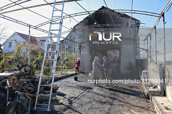 People stand outside a house damaged by a large-scale Russian missile strike in the Odesa region, southern Ukraine, on November 17, 2024. In...