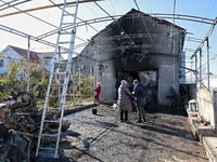 People stand outside a house damaged by a large-scale Russian missile strike in the Odesa region, southern Ukraine, on November 17, 2024. In...