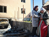 Women who survive a large-scale Russian missile strike share a hug outside a damaged house in the Odesa region, Ukraine, on November 17, 202...