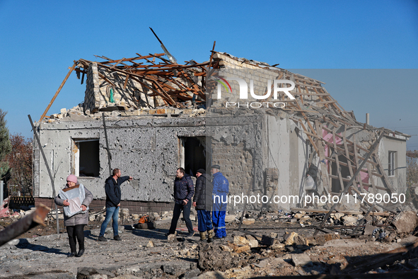 People stand outside a house destroyed by a large-scale Russian missile strike in the Odesa region, Ukraine, on November 17, 2024. In the re...