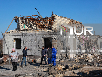 People stand outside a house destroyed by a large-scale Russian missile strike in the Odesa region, Ukraine, on November 17, 2024. In the re...