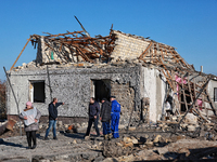 People stand outside a house destroyed by a large-scale Russian missile strike in the Odesa region, Ukraine, on November 17, 2024. In the re...