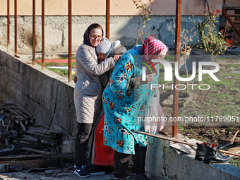 Women who survive a large-scale Russian missile strike stand among the debris in the Odesa region, Ukraine, on November 17, 2024. In the rec...